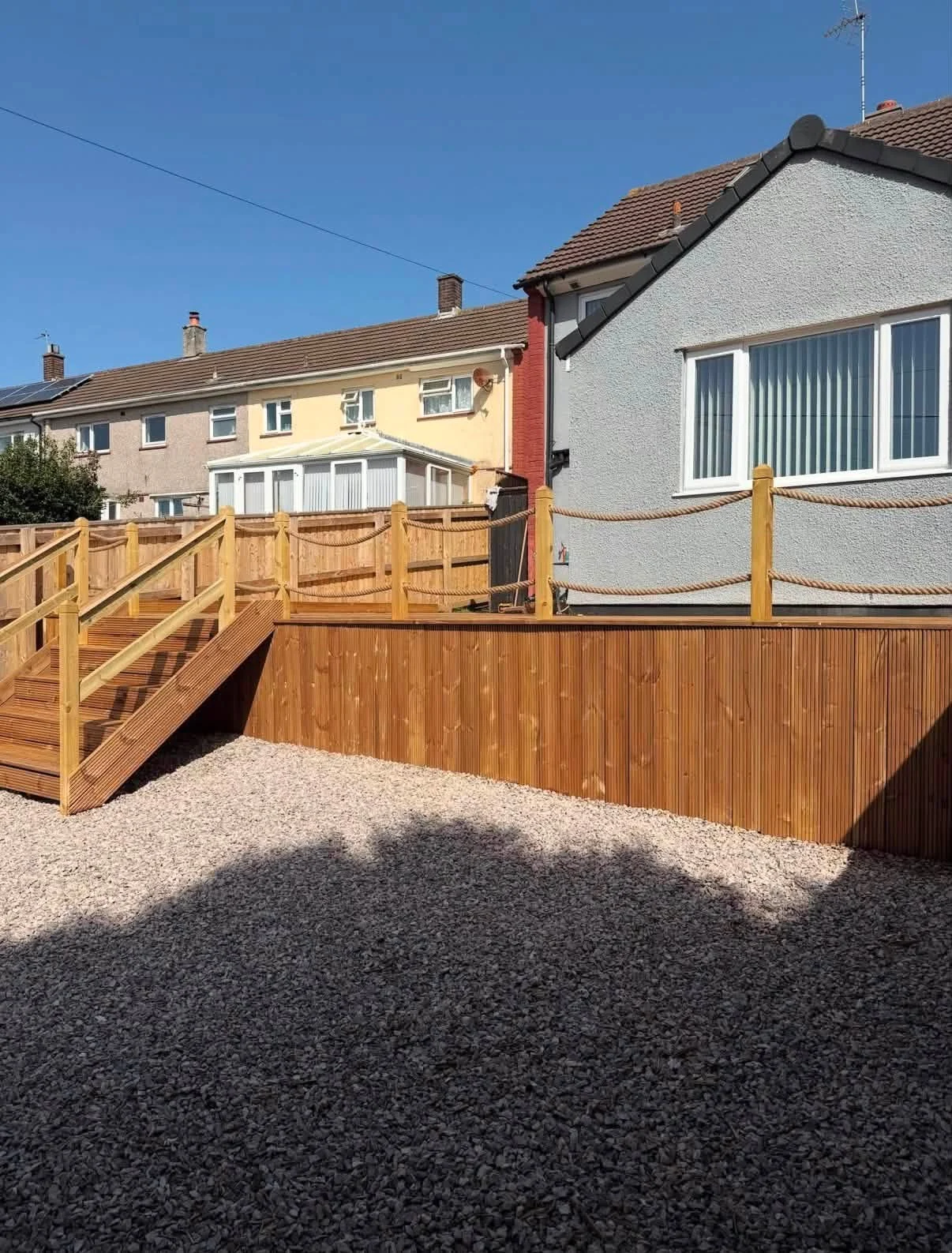 Raised deck with steps and rope balustrade behind a terrace